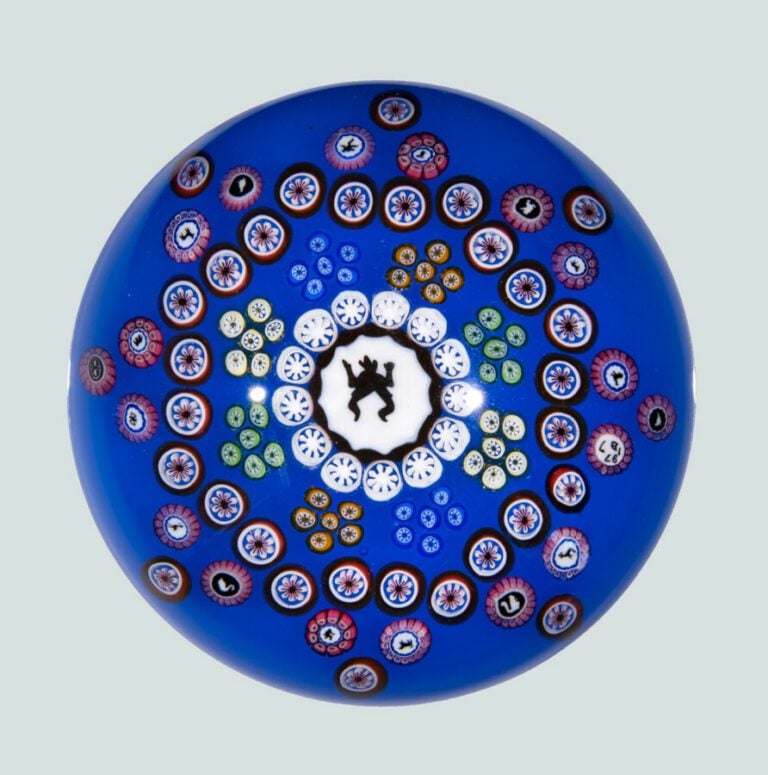 Baccarat. Presse-papiers signé et daté B1977, à fond bleu orné de bonbons polyc…