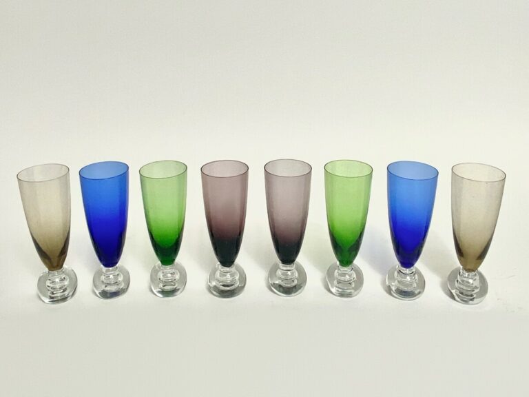 Coffret de 8 flûtes en verre coloré sur piétement boule.