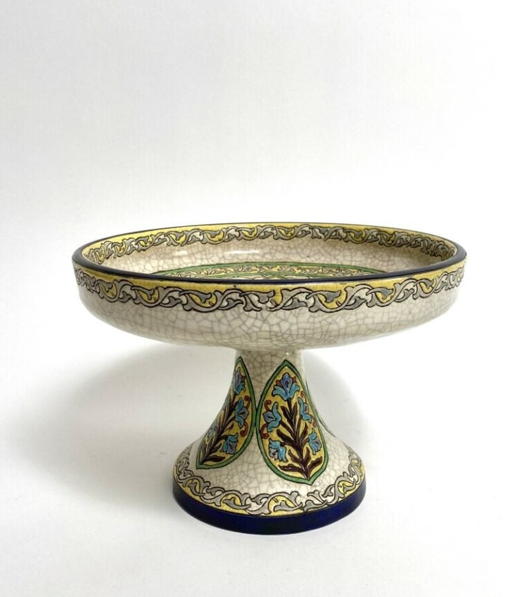 LONGWY. Coupe sur piédouche en faïence émaillée beige à craquelures à motif Flo…