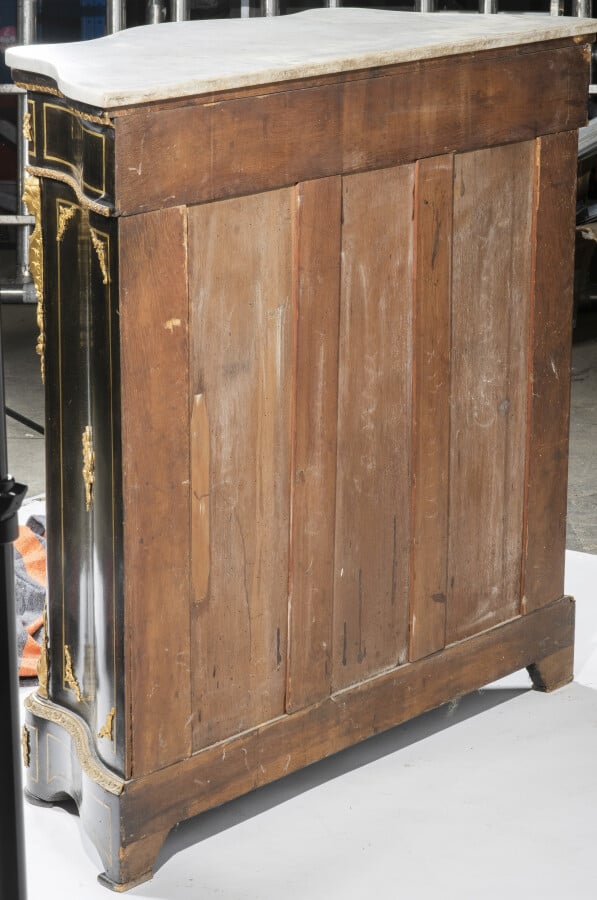 Meuble à hauteur d'appui en bois noirci de forme mouvementée ouvrant par une po…