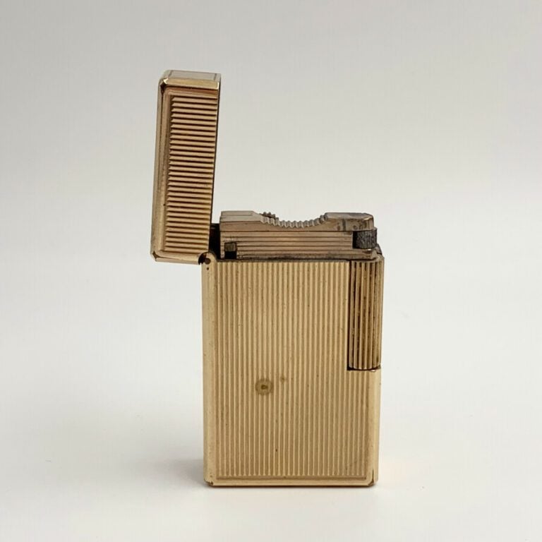 S.T. DUPONT - BRIQUET rectangulaire en métal doré guilloché. Signé S.T. DUPONT…