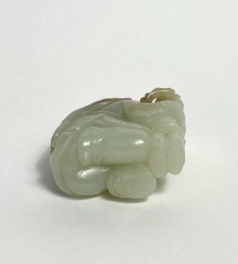 Statuette en jade, représentant deux personnages s'abritant sous de grandes feu…