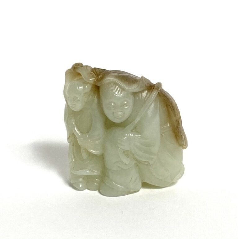 Statuette en jade, représentant deux personnages s'abritant sous de grandes feu…