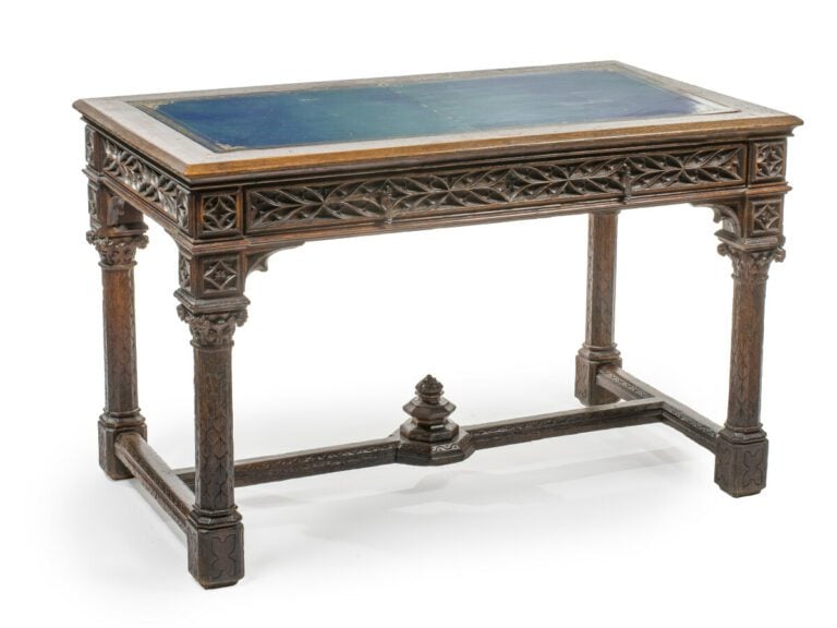 Table rustique en chêne sculpté de motifs végétaux stylisés en ceinture ; elle…