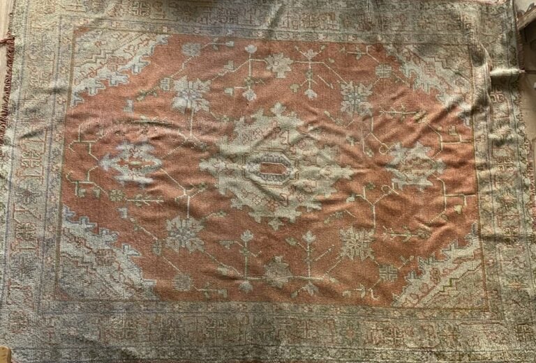 Tapis d'Orient à médaillon central sur fond corail ; bordure sur fond beige (us…