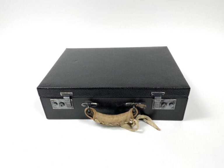 Valise en cuir noir grainé siglée "Au départ, 29 avenue de l'Opéra, Paris" cont…