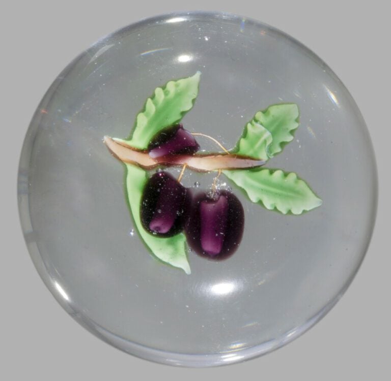 Baccarat.Presse-papiers orné de deux prunes violettes sur une branche ocre port…