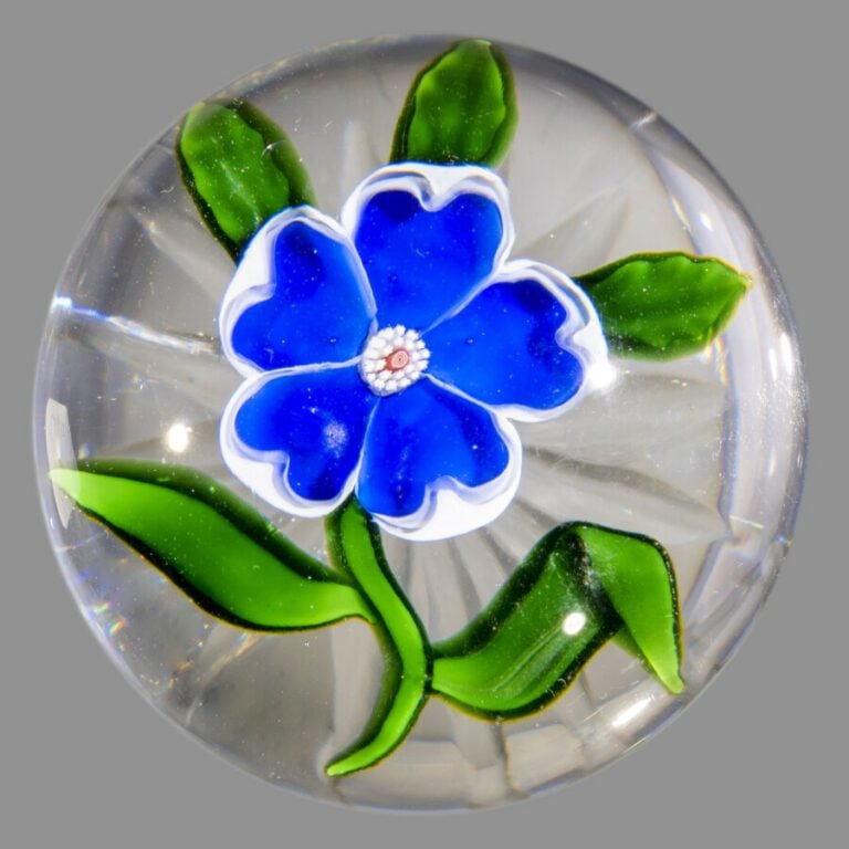 Baccarat.Presse-papiers orné d'une églantine bleue à bord blanc, sur une tige v…