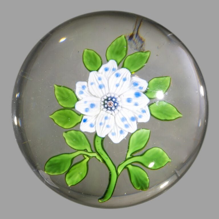 Baccarat. Presse-papiers orné d'une fleur de blé blanche à pois bleus, sur une…