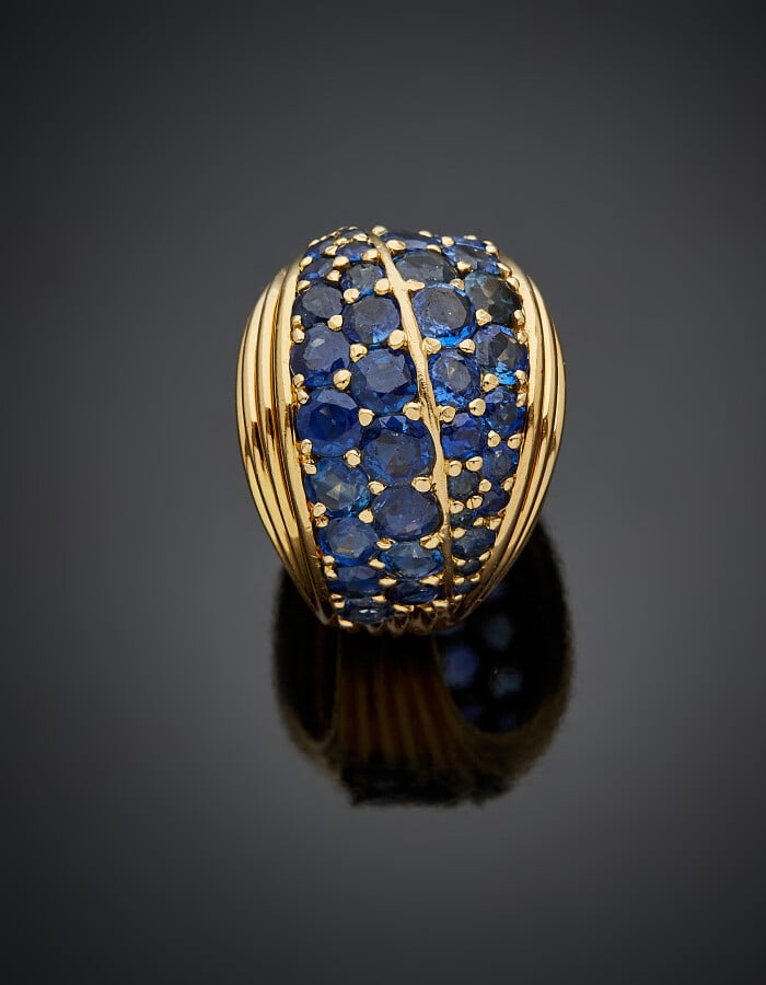 BAGUE "boule" en or jaune (750) godronné, serti de quatre alignements de saphir…