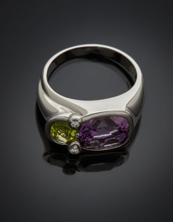 BAGUE chevalière en or gris (750) serti d'un péridot ovale et d'une améthyste d…