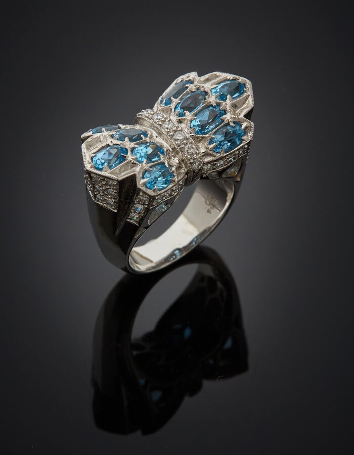 BAGUE chevalière "noeud" en or gris (750) finement ciselé, serti de dix topazes…