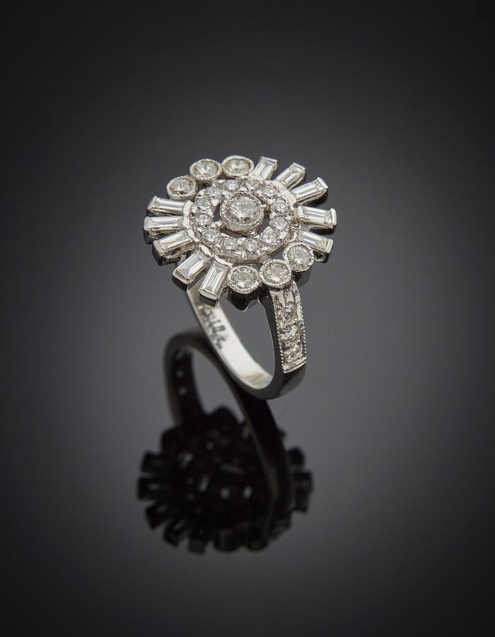 BAGUE circulaire stylisée, en or gris (750) ajouré, à motifs rayonnants, serti…