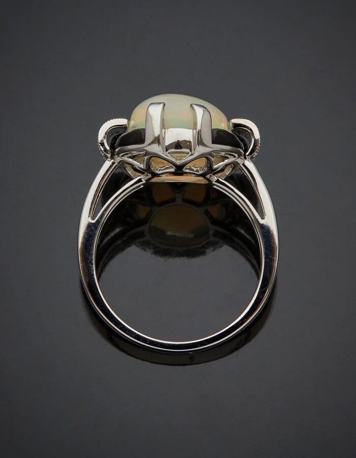 BAGUE en or gris (750) centré d'une opale cabochon de forme ovale, épaulée de d…