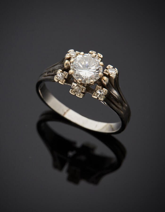 BAGUE en or gris (750) serti d'un diamant taille brillant entouré de six diaman…