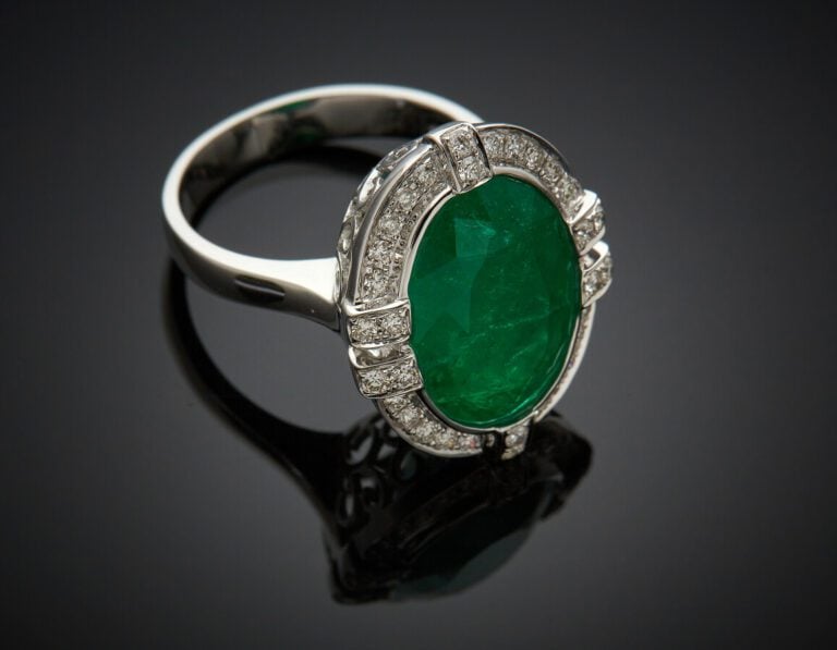 BAGUE en or gris (750) serti d'une émeraude pesant 8,2 carats env. (fêle), ento…