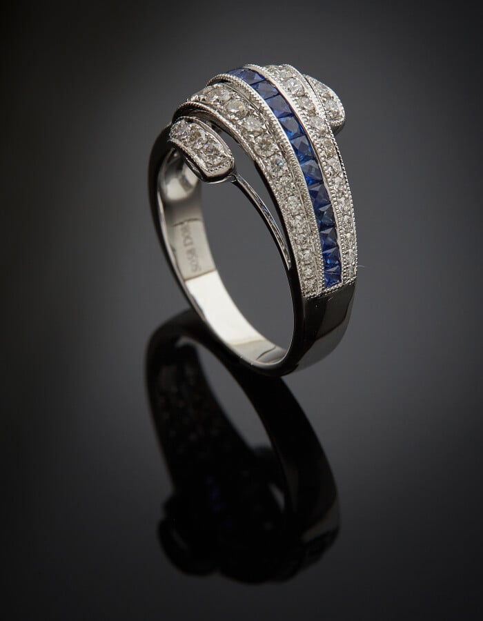 BAGUE "enroulement" en or gris (750) centrée d'un alignement de saphirs calibré…