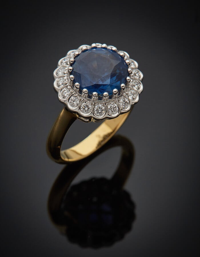 BAGUE "marguerite" ronde en or jaune et or gris (750) serti d'un saphir rond pe…