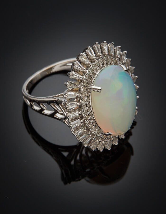 BAGUE ovale en or gris (750) serti d'une opale cabochon, entourée de diamants t…