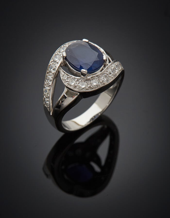 BAGUE « sinueuse » en or gris (750) ajouré, centré d'un saphir pesant 2,51 cara…