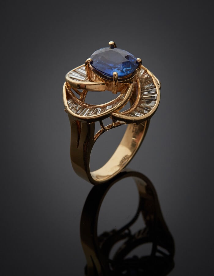 BAGUE "tourbillon" en or jaune (585) 14 carats, ajouré, serti d'un saphir ovale…