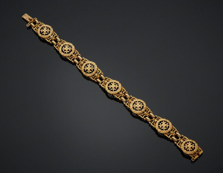 BRACELET en or jaune (750) ajouré à motifs de couronnes, fleurs et volutes. - T…