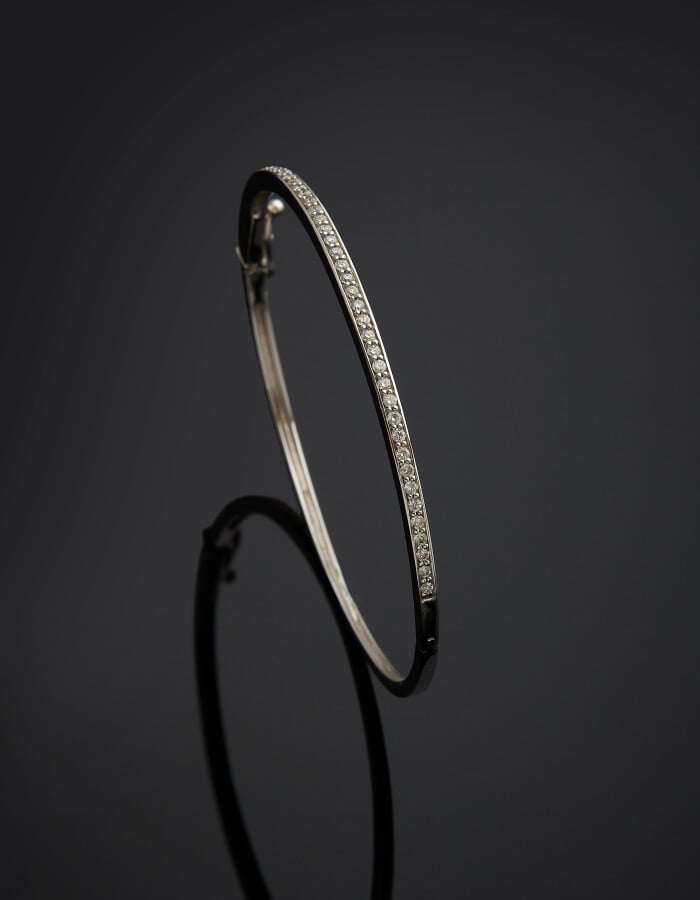 BRACELET fin rigide ouvrant en or gris (750) serti d'un alignement de diamants…
