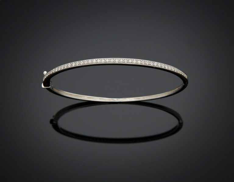 BRACELET fin rigide ouvrant en or gris (750) serti d'un alignement de diamants…