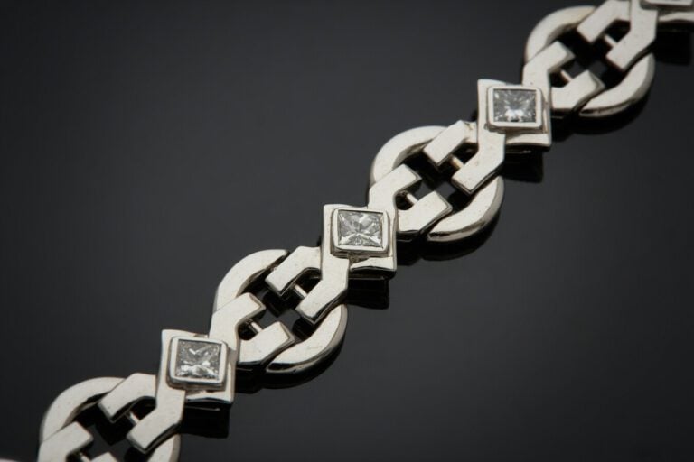 BRACELET géométrique articulé et ajouré en or gris (750) serti de neuf diamants…