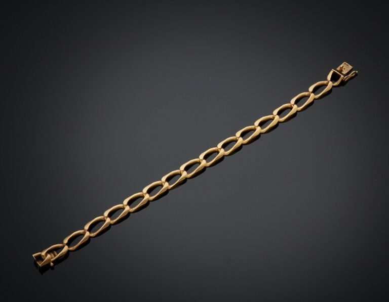 BRACELET gourmette limée en or jaune (750). - Travail français. - Long.: 19,5 c…
