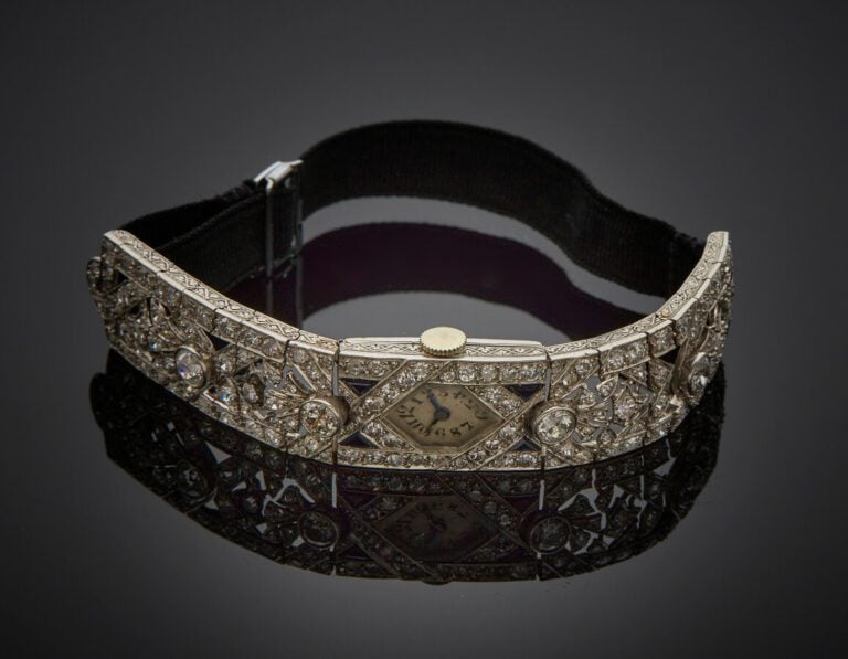 BRACELET MONTRE de dame hexagonale, en platine (800) ajouré et articulé, à moti…