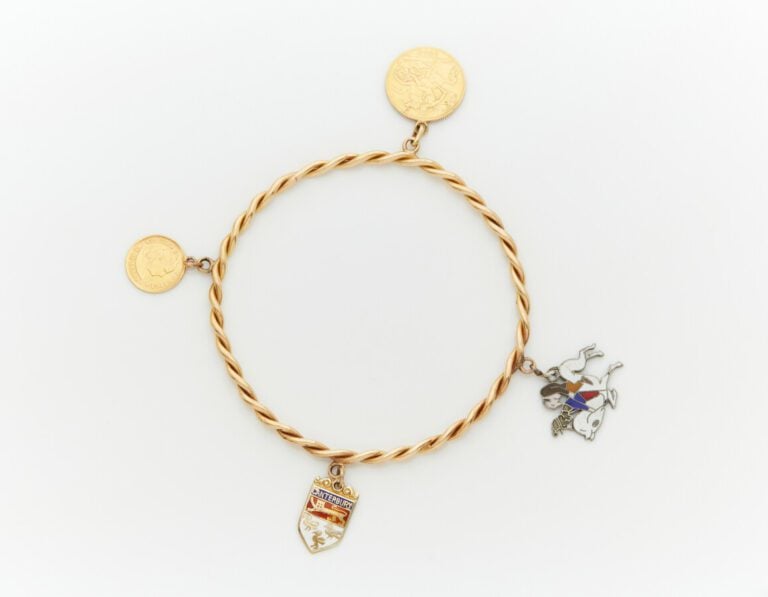 BRACELET rigide torsadé en or jaune (750) retenant en pampille : - - 1/2 souver…