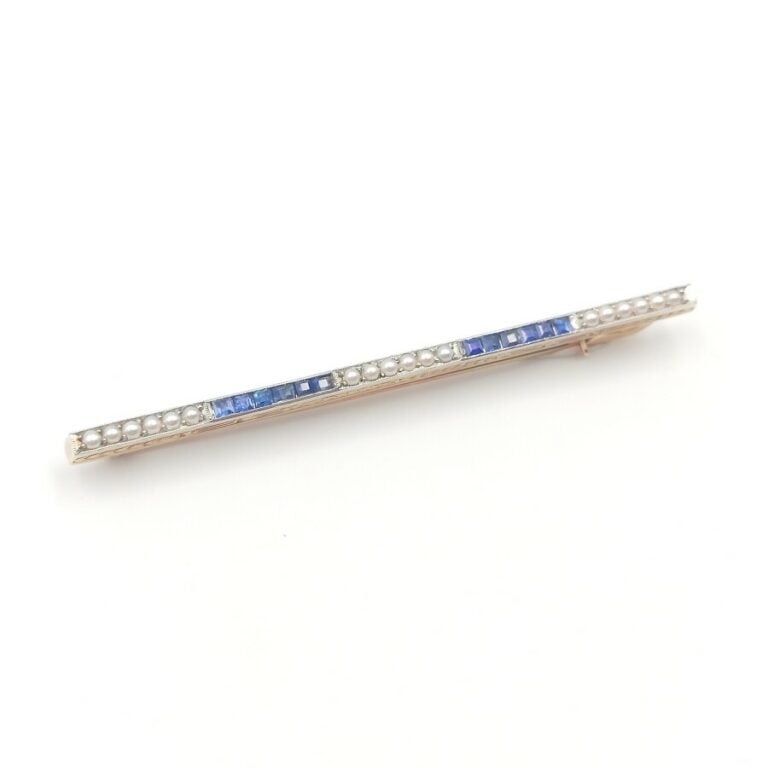 BROCHE barrette en or jaune (750 millièmes) serti de saphirs calibrés et de pet…