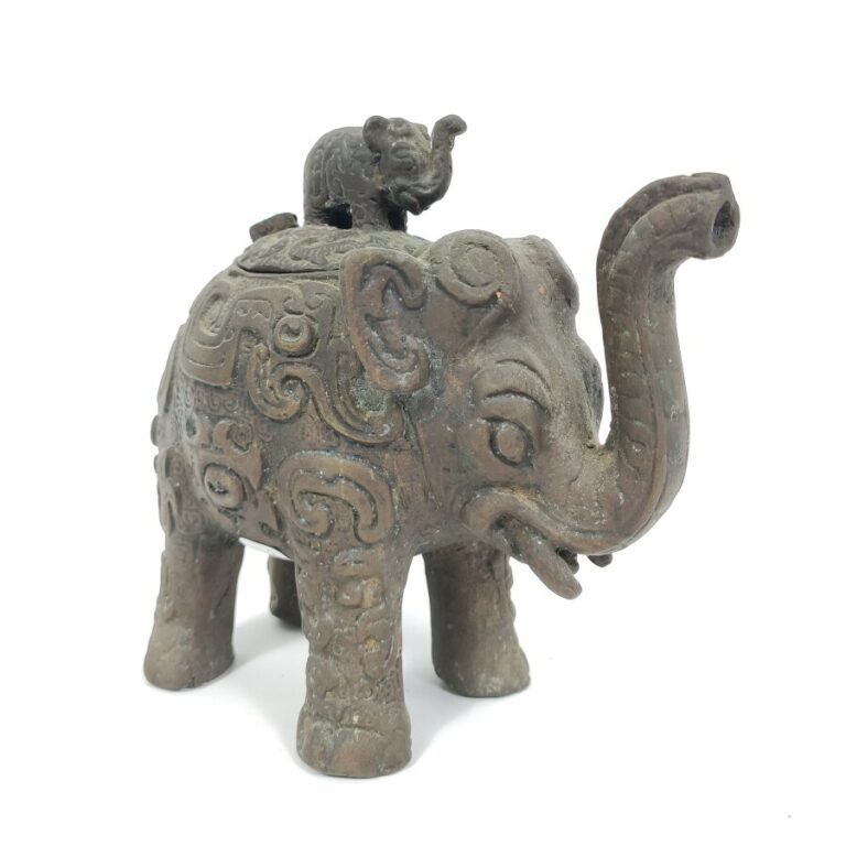 Brûle parfum en bronze en forme d'éléphant, ses flancs à motifs archaïsants, sa…