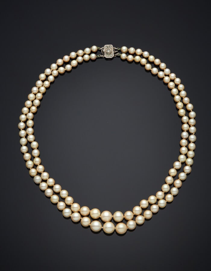 COLLIER composé de deux rangs de perles de culture blanches. Fermoir octogonal…