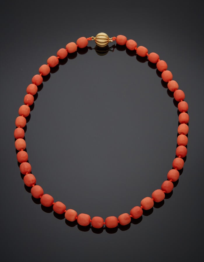 COLLIER composé d'un rang de 42 perles de corail. Fermoir "boule" godronnée en…