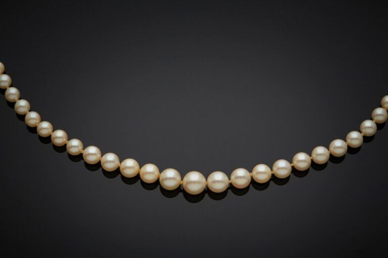 COLLIER composé d'un rang de perles de culture de couleur crème, en chute. Ferm…