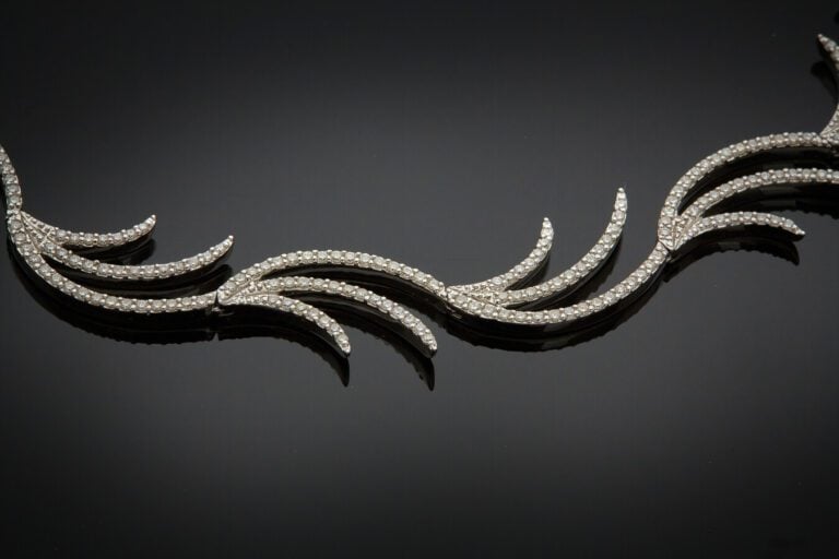 COLLIER "flammes" en or gris (750) articulé, partiellement serti de diamants ta…