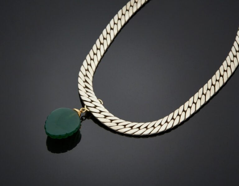 COLLIER gourmette plate en argent (min. 800) centré d'un godron appliqué en or…