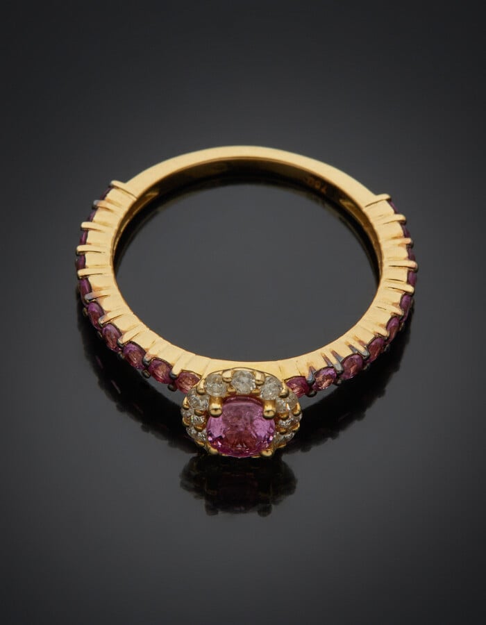 Fine BAGUE en or jaune (750) centré d'un saphir rose de forme ovale, entouré de…