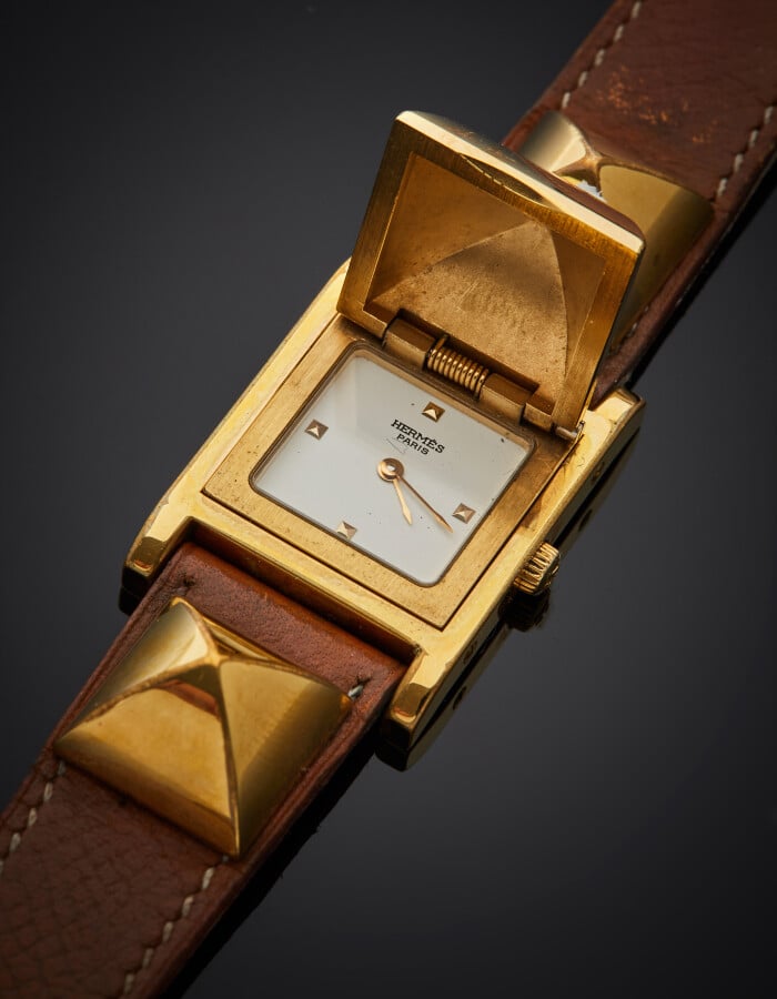 HERMES - BRACELET MONTRE modèle « Médor », carrée en métal doré à trois motifs…