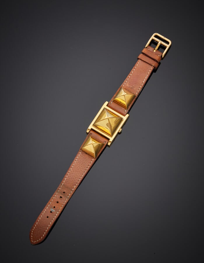 HERMES - BRACELET MONTRE modèle « Médor », carrée en métal doré à trois motifs…