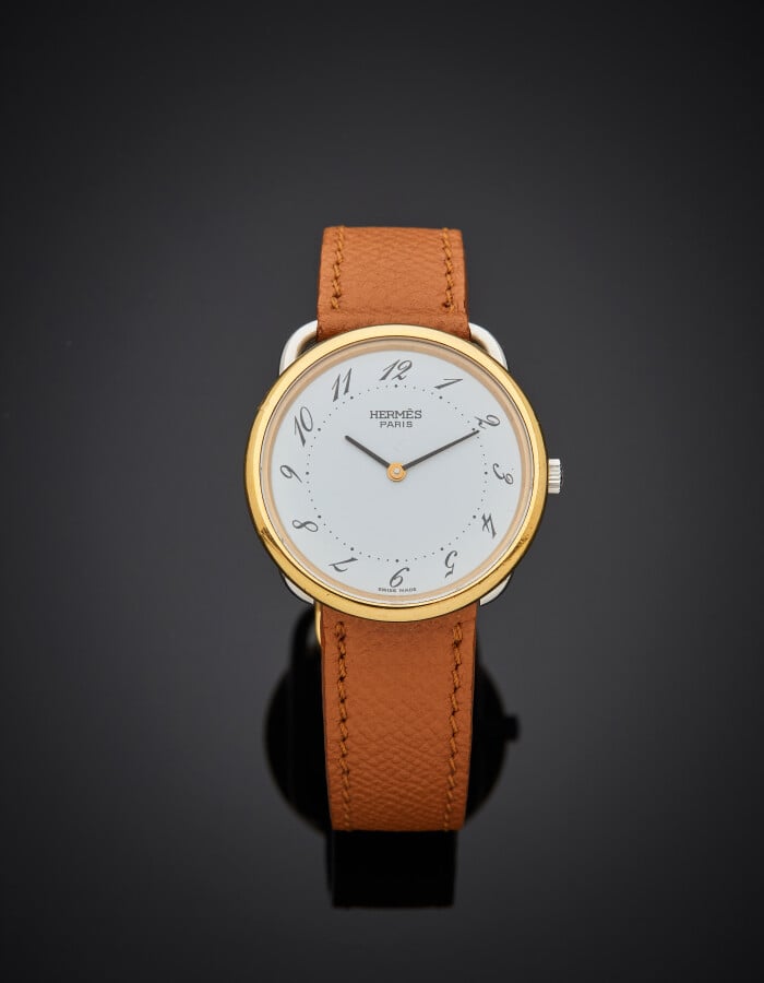 HERMES - BRACELET MONTRE ronde modèle « Arceau » en acier et métal doré, ajouré…