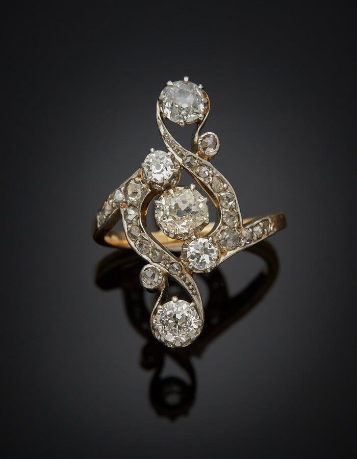 Longue BAGUE "volutes" en platine (min. 800) et or jaune (750) ajouré, serti de…