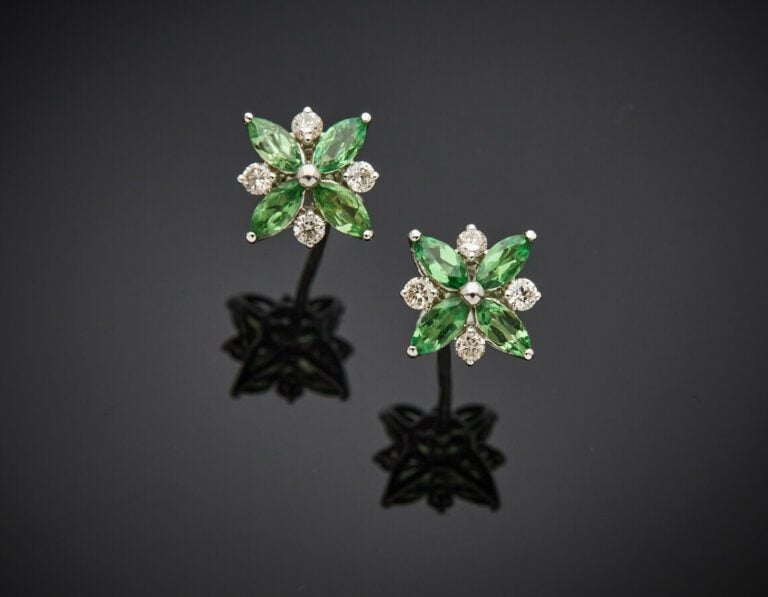 Paire de CLOUS d'OREILLES « fleurettes » en or gris (750) serti de quatre grena…