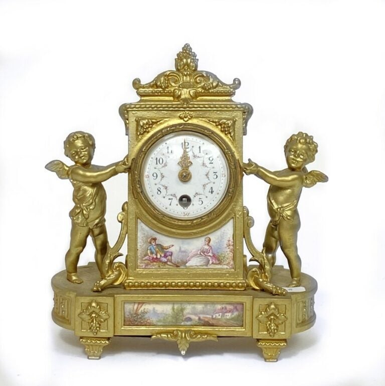 Pendulette en bronze redoré et plaque d' émail entre deux amours. - 21x18 cm