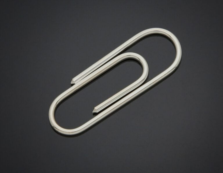 PINCE à BILLETS "trombone" en argent (min. 800) uni. - Long.: 6,4 cm. Poids : 1…