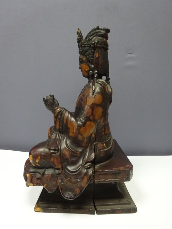 STATUE D'UNE DIVINITE EN BOIS LAQUE - XXe siècle - Assis sur un socle carré, el…