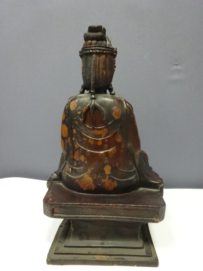 STATUE D'UNE DIVINITE EN BOIS LAQUE - XXe siècle - Assis sur un socle carré, el…
