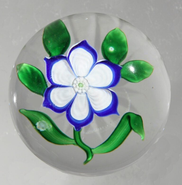 Baccarat. - Presse-papiers orné d'une anémone blanche et bleue à six pétales og…